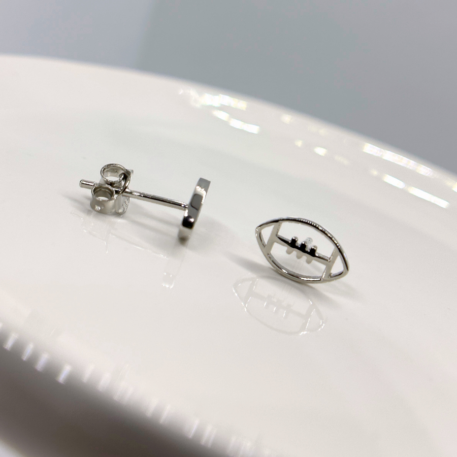Tiny football earrings shown in silver.