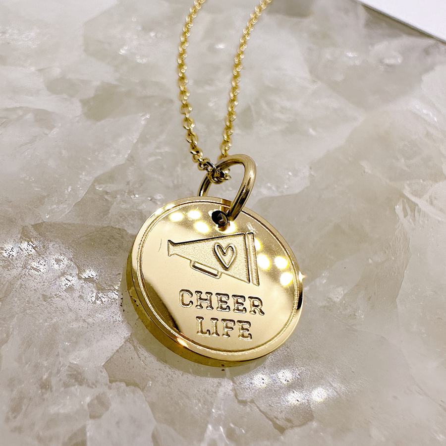 Cheer disc charm necklace in gold.