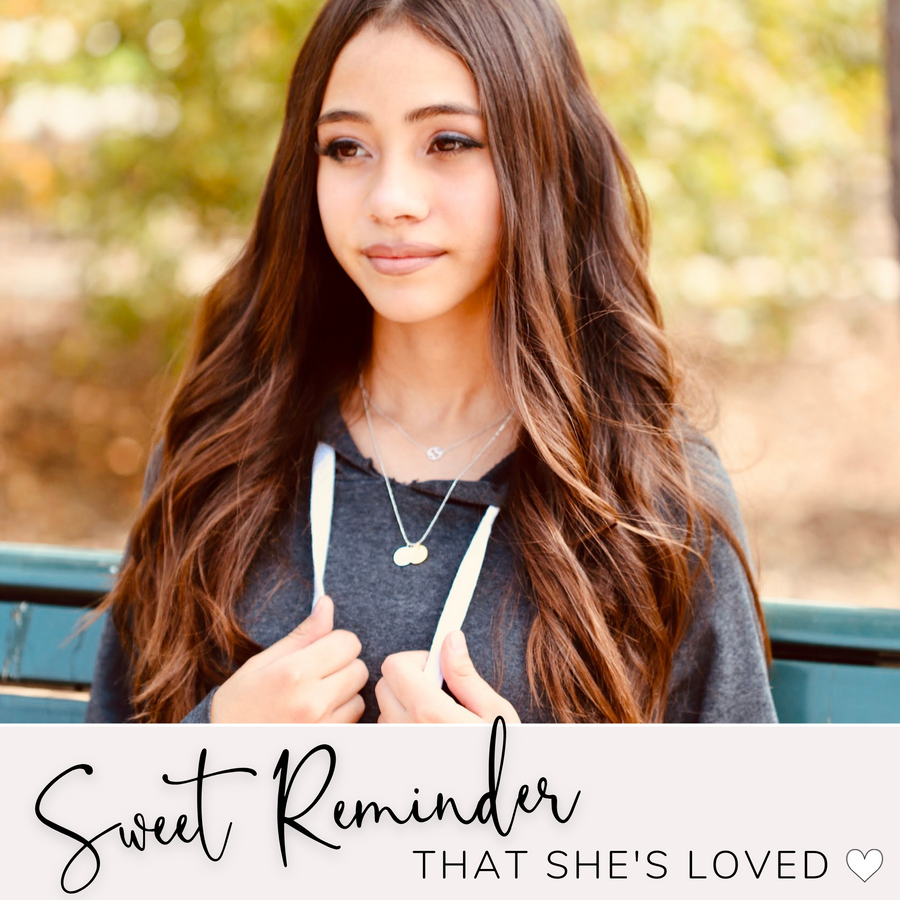 Brunette Teen Model wearing adjustable length Dainty Tennis Charm Necklace with Tennis charm, and 'She believed she could so she did' charm, layered with .925 silver necklace, a sweet reminder that she's loved..